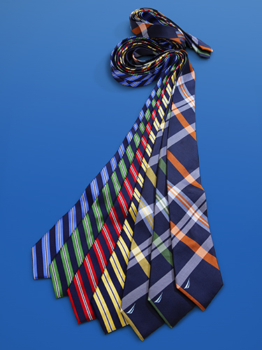 Several colorful neckties are laid out on a blue surface. The ties feature various patterns, including stripes and plaid, in colors such as blue, red, green, yellow, and orange.
